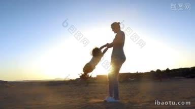 慢动作的母亲旋转的儿子在海滩上明亮的傍晚<strong>阳光</strong>快乐的家庭假期